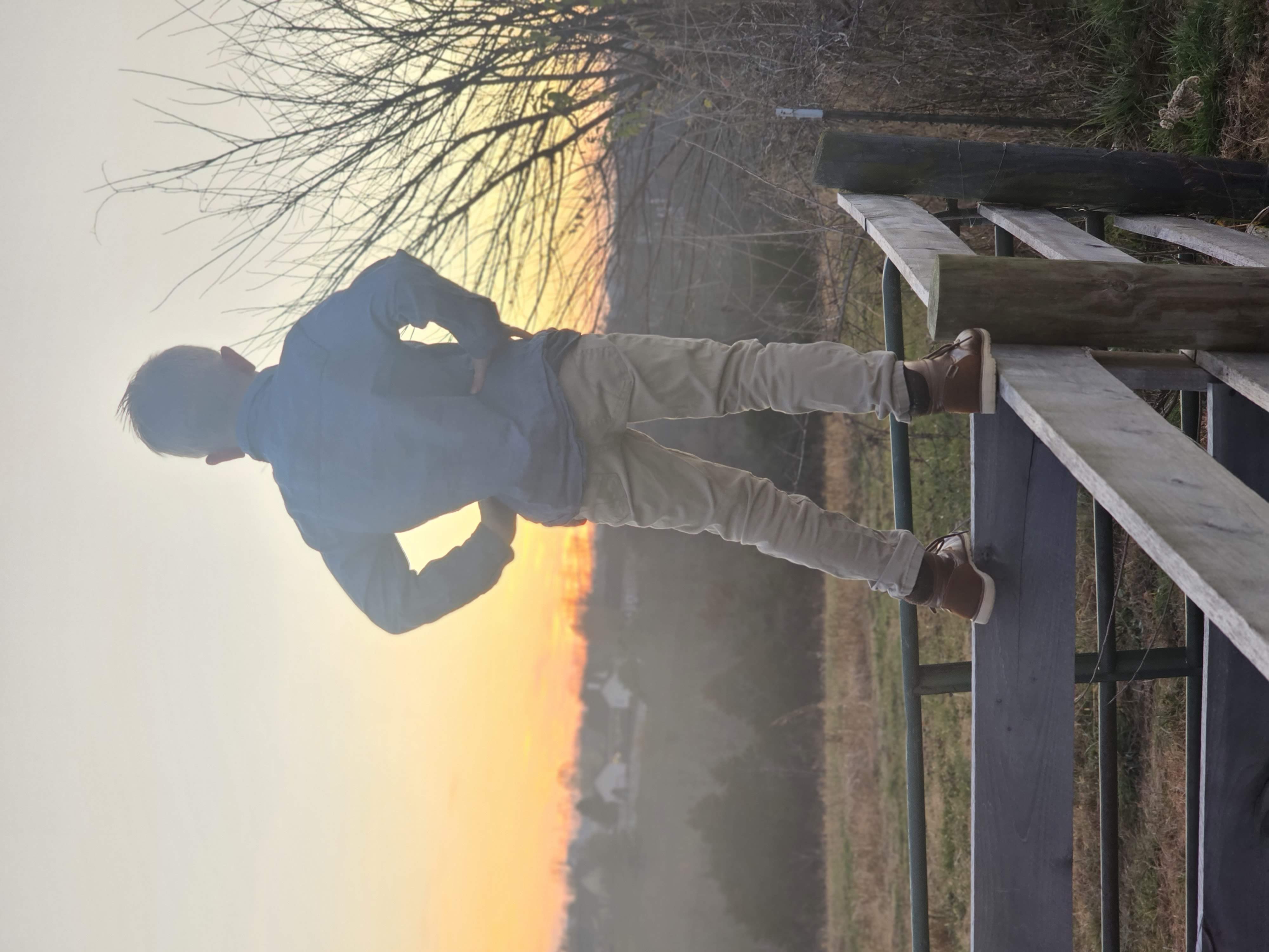 A child standing on a farm fence looking out over Kentucky fields at sunset, representing the vision of land ownership