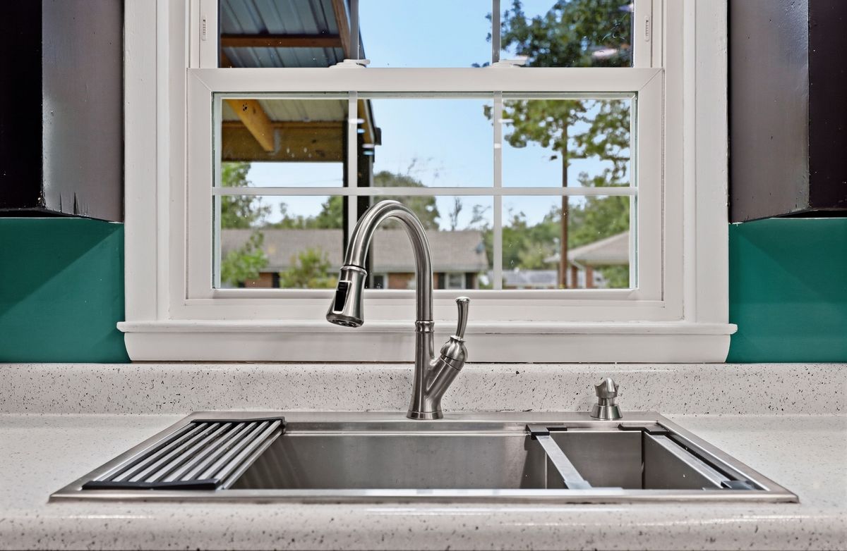 Kitchen sink detail with pull-down faucet and window to porch