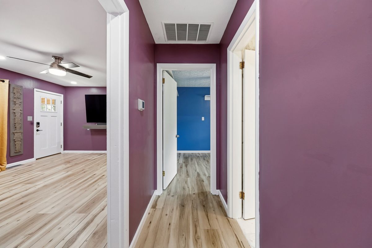 Hallway connecting living room and bedrooms with smart thermostat