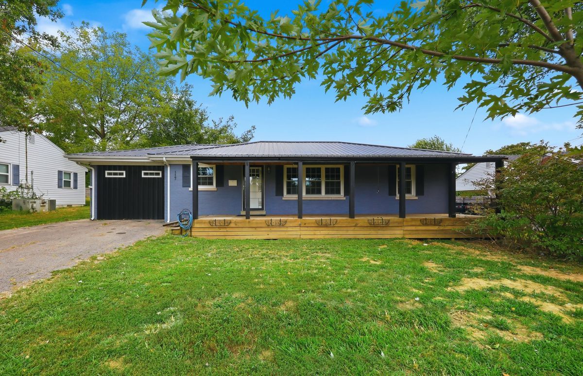 Front of home with covered wood porch, new metal roof, and attached garage