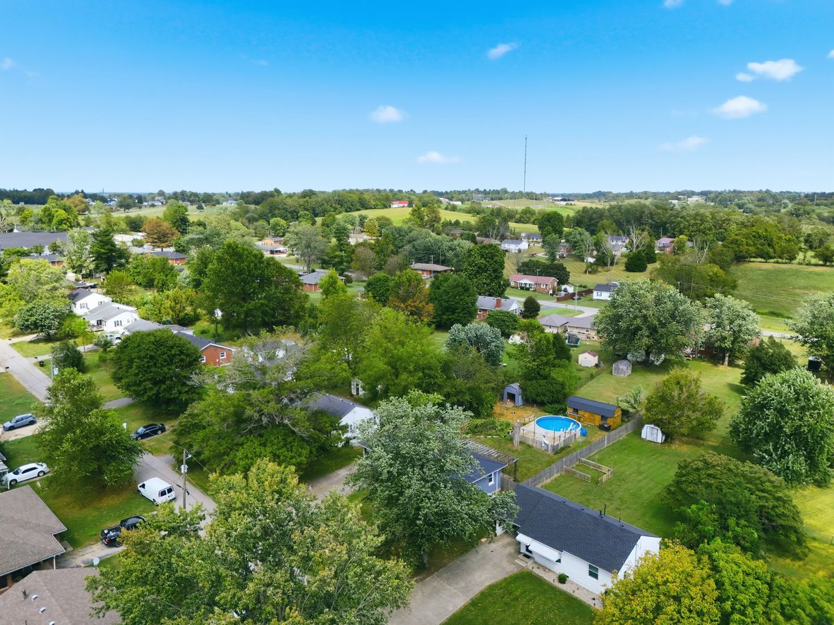 Aerial of neighborhood showing pool and surrounding homes