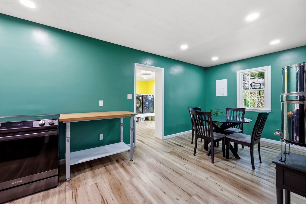 Kitchen with teal walls, Samsung range, butcher block work table, and dining area