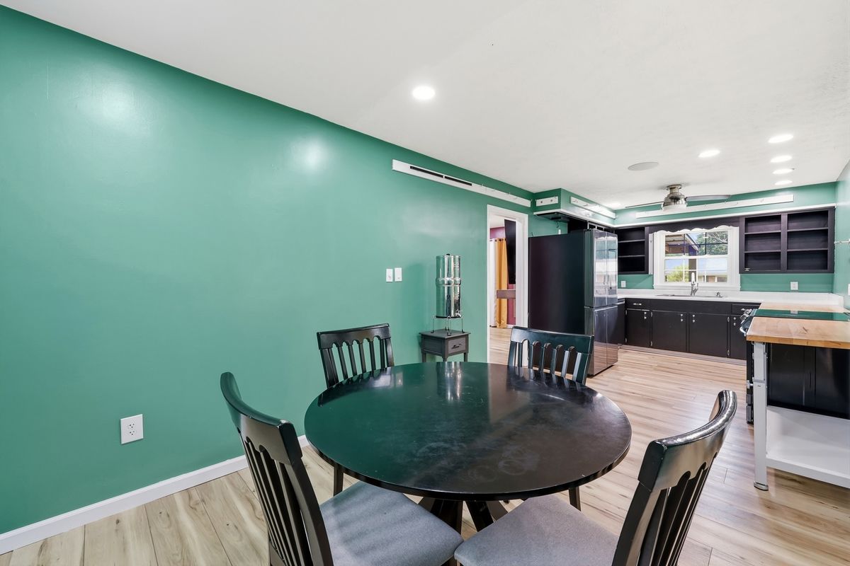 Dining area looking into kitchen with dark cabinets and stainless appliances