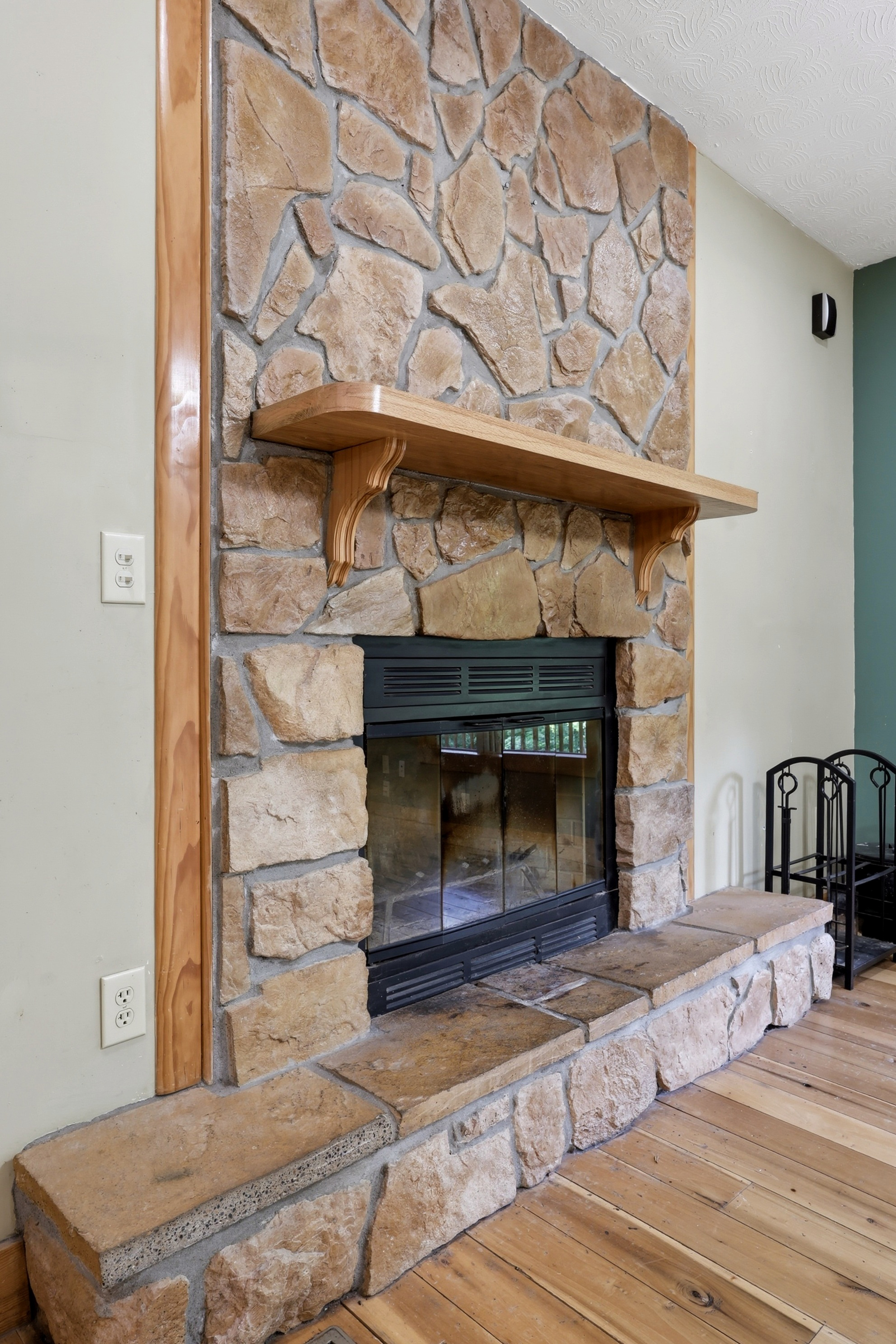 Stone fireplace close-up with wood mantel