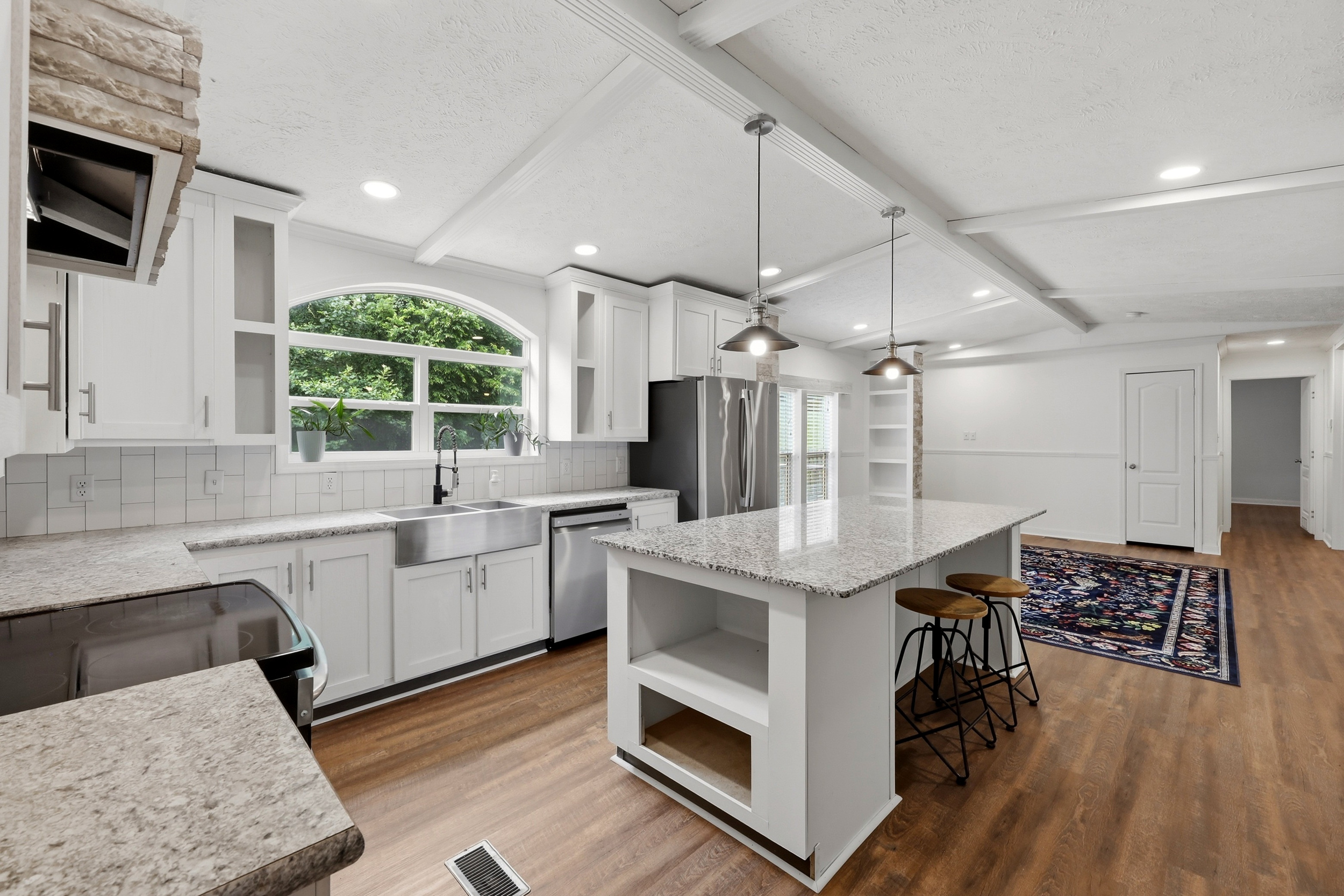 Kitchen with stainless appliances and arched window