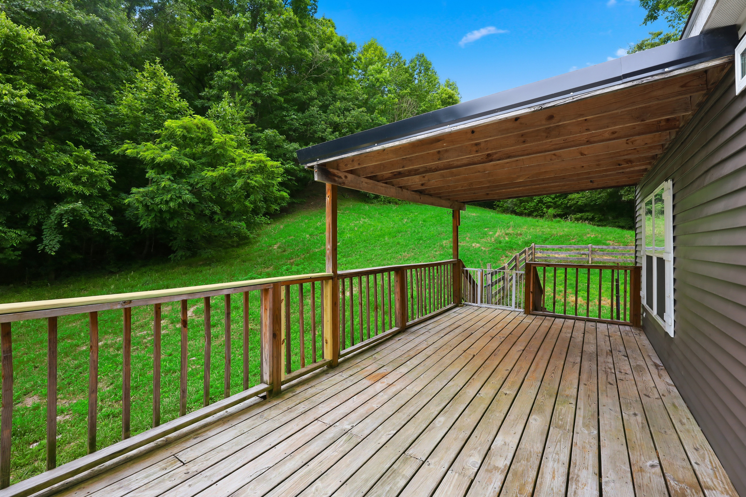 Covered deck overlooking green hillside