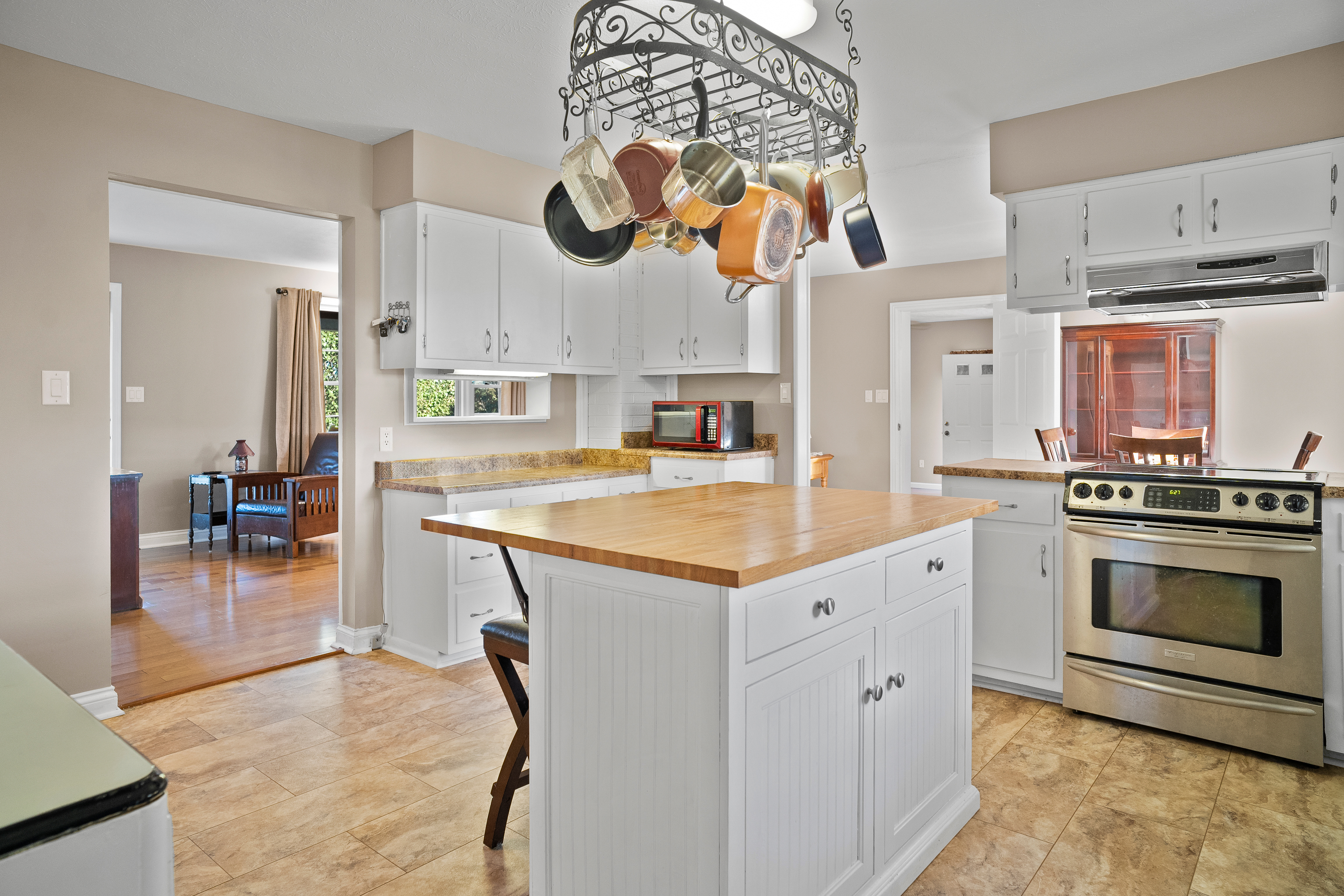 Kitchen with butcher block island and pot rack