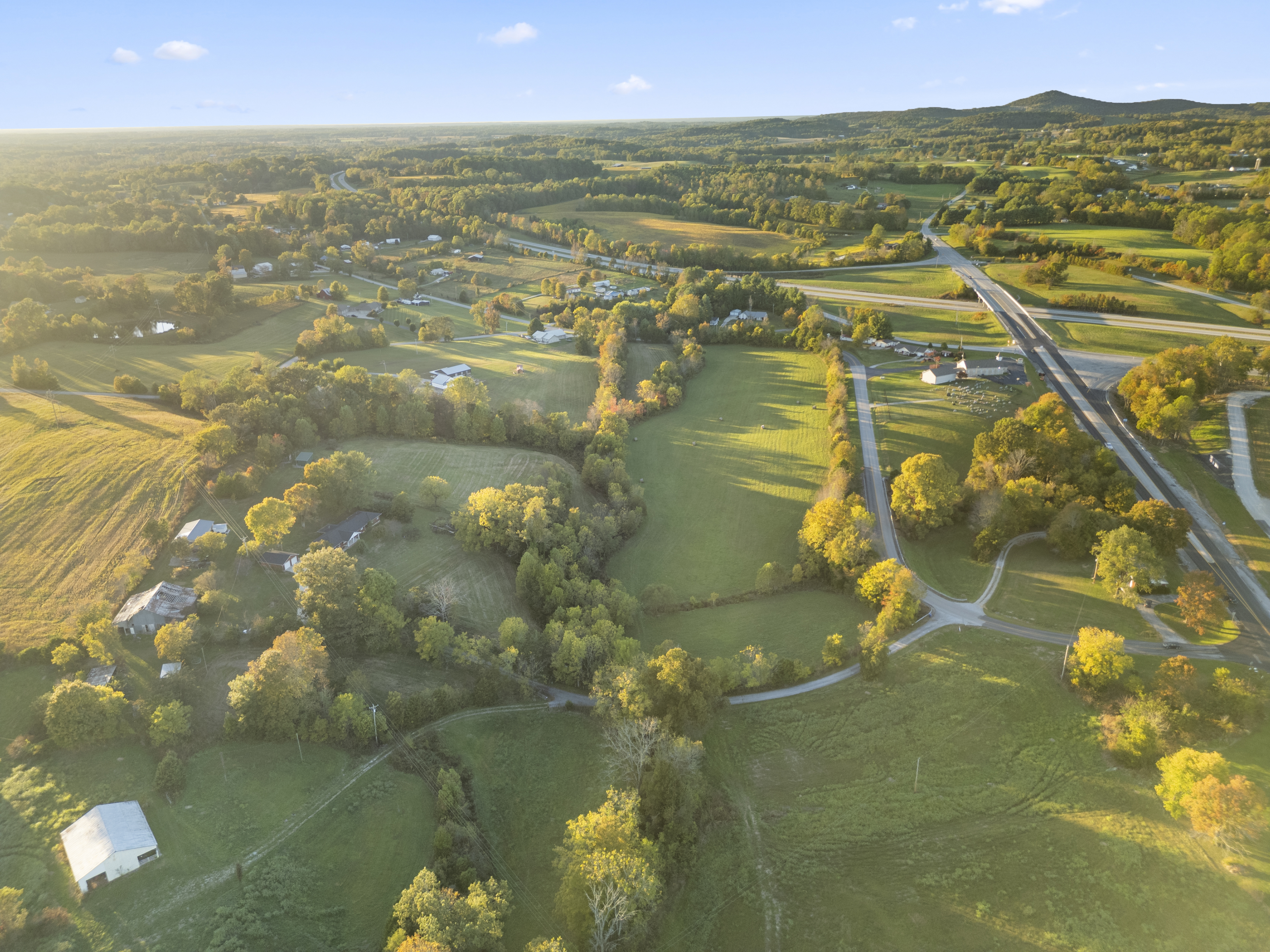 Aerial of rolling pastureland at golden hour
