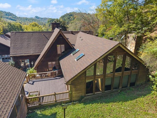 Aerial view of in-ground diving pool, pool house, and rear decks