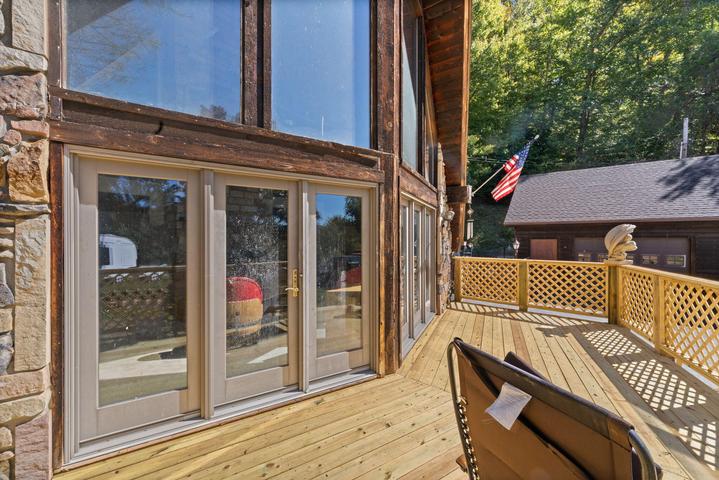 New front deck with railing and wooded view