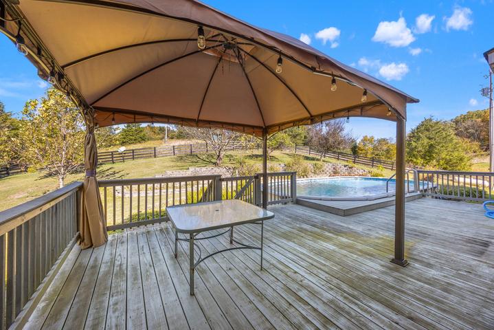 Swimming pool with surrounding patio and countryside views