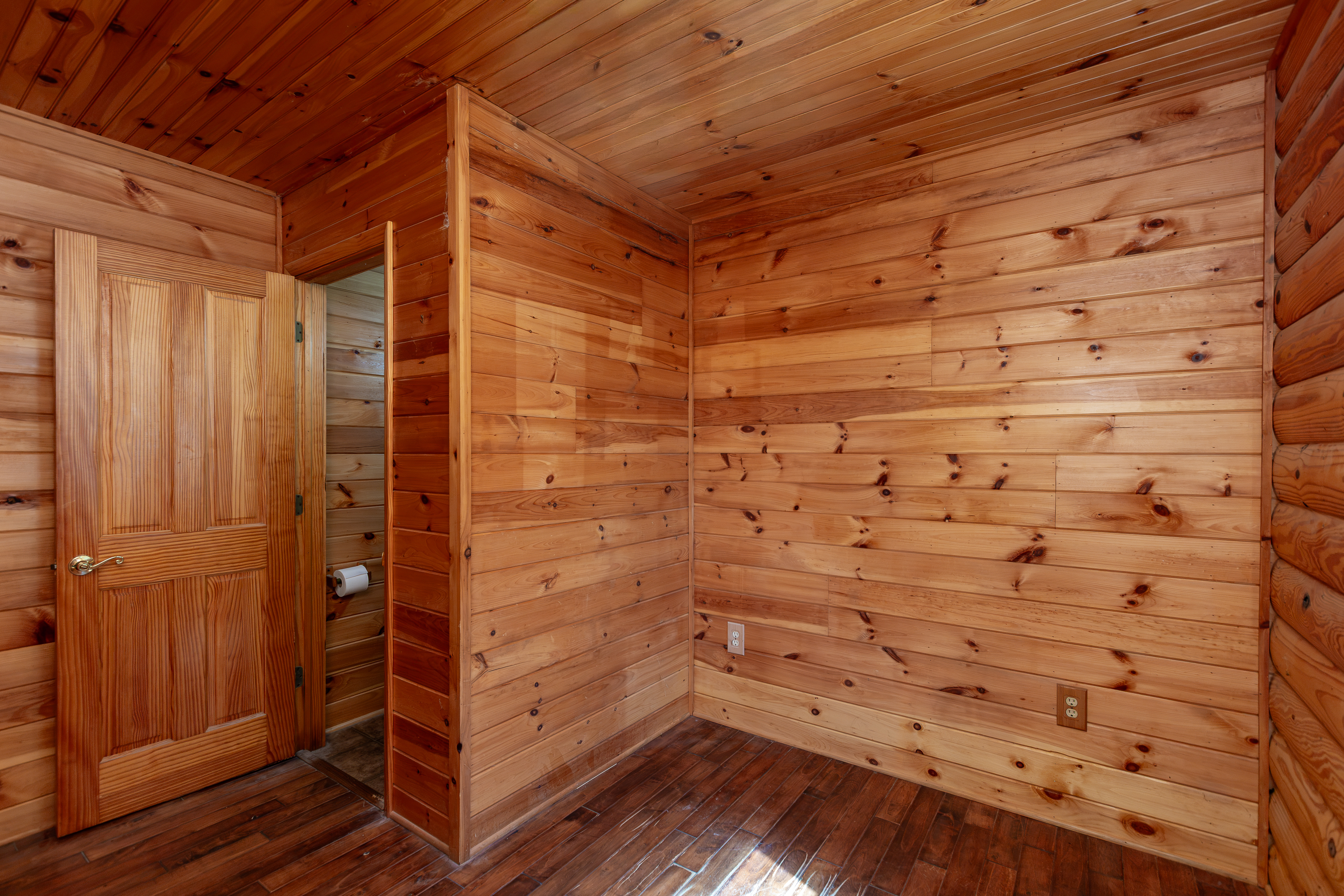 Bedroom with log walls and adjoining bathroom